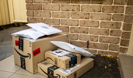 Unwanted Amazon packages left behind in front of door of consumers as part of brushing scam.