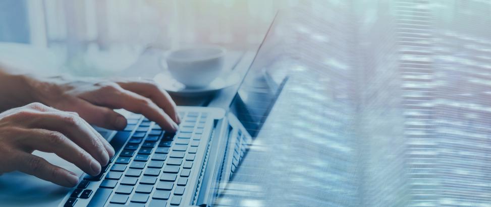 Person typing on a notebook while working.