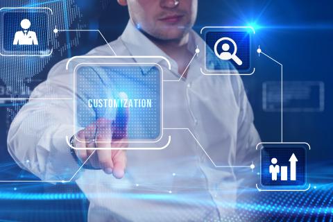 A businessman taps on a virtual screen of the future with the inscription Customization.