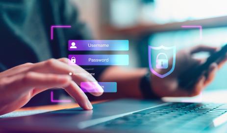 Password Authentication User sitting in front of a notebook and entering his username and password on a virtual login screen.