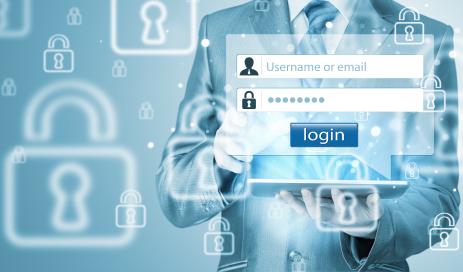Product features of a Secure login-process Businessman holding a tablet device and entering login credentials and standing in front of a wallpaper with many locks symbolizing a secure authentication process.
